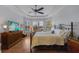 Inviting main bedroom with decorative tray ceiling, comfortable bed, hardwood floors and bright windows at 12740 Del Corso Loop, Lakewood Ranch, FL 34211