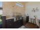 Outdoor kitchen features stainless steel grill, sink, mini-fridge, granite counters and brick flooring at 12740 Del Corso Loop, Lakewood Ranch, FL 34211