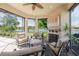 Inviting screened lanai includes an outdoor fireplace, seating, and serene lake views at 12740 Del Corso Loop, Lakewood Ranch, FL 34211