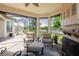 Cozy screened-in patio with comfortable seating, brick flooring, a fireplace, and views of a serene lake at 12740 Del Corso Loop, Lakewood Ranch, FL 34211