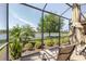 A covered outdoor seating area features a lovely view of the manicured lawn and lake at 12740 Del Corso Loop, Lakewood Ranch, FL 34211
