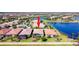 Aerial view of home with a tile roof, screened lanai, palm trees, and water view at 13724 Quinta St, Venice, FL 34293