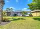 Well-manicured backyard with lush green lawn and tropical landscaping surrounding a screened-in patio at 13724 Quinta St, Venice, FL 34293