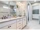 Elegant bathroom features double sinks, granite countertops, with a walk-in shower and a spacious walk-in closet at 13724 Quinta St, Venice, FL 34293