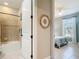 Bathroom showcasing tile shower, open door to bedroom, and beachy decor at 13724 Quinta St, Venice, FL 34293