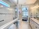 Luxury bathroom featuring a glass-enclosed shower with tiled accents, a vanity with double sinks, and access to the bedroom at 13724 Quinta St, Venice, FL 34293