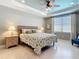 A cozy bedroom features a ceiling fan, tiled floors, and a stylish bed with matching lamps and a lovely comforter at 13724 Quinta St, Venice, FL 34293