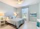 A serene bedroom with a ceiling fan, tiled floor, decorative headboard, matching lamps, and a beach themed painting at 13724 Quinta St, Venice, FL 34293
