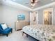 Inviting bedroom with a flat screen TV, comfortable seating, and light-colored furniture complimenting the tiled floor at 13724 Quinta St, Venice, FL 34293