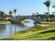 Scenic bridge over a waterway, surrounded by lush landscaping and mature palm trees, enhancing community aesthetics at 13724 Quinta St, Venice, FL 34293