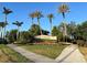 Beautifully landscaped community entrance with mature palm trees, flower beds, and well-maintained sidewalks at 13724 Quinta St, Venice, FL 34293