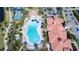 Overhead shot of a beautiful community pool, surrounded by palms, a clubhouse, and many lounge chairs at 13724 Quinta St, Venice, FL 34293