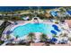 Resort-style community pool with plenty of lounge chairs, palm trees, and a hot tub for relaxation and recreation at 13724 Quinta St, Venice, FL 34293