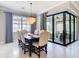 Chic dining area with a chandelier, modern design, and sliding doors opening to an outdoor space at 13724 Quinta St, Venice, FL 34293