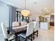 Spacious dining room with a chandelier and open-concept layout leading into the kitchen and living area at 13724 Quinta St, Venice, FL 34293