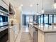 Open kitchen design with an island, stainless steel appliances, and seamless transition to the dining area at 13724 Quinta St, Venice, FL 34293