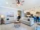 Cozy living room featuring neutral tones, a modern ceiling fan, and seamless access to the kitchen at 13724 Quinta St, Venice, FL 34293