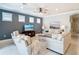 Well-lit living room with comfortable seating, a ceiling fan, and modern entertainment center at 13724 Quinta St, Venice, FL 34293