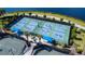 Aerial view of multiple, active pickleball courts with shade pavilions and lush landscaping by a lake at 13724 Quinta St, Venice, FL 34293