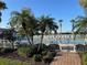 Pool area surrounded by lush landscaping with lounge chairs and umbrellas and secured by a metal fence at 13724 Quinta St, Venice, FL 34293