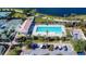 Aerial view of a community pool with tennis courts, lounge chairs, landscaping and adjacent parking at 13724 Quinta St, Venice, FL 34293