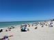 Expansive sandy beach with beachgoers enjoying the sun, clear blue skies, and tranquil ocean waters at 13724 Quinta St, Venice, FL 34293