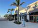 Shops featuring outdoor dining and pedestrian-friendly sidewalks, palm trees, and storefront signage at 13724 Quinta St, Venice, FL 34293