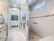 Bright bathroom with a tiled shower, glass enclosure, a built-in bench, and a view into the walk-in closet at 13724 Quinta St, Venice, FL 34293