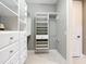Well-organized walk-in closet with multiple shelves, drawers, and hanging rods for ample storage solutions at 13724 Quinta St, Venice, FL 34293