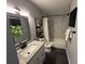 Bathroom featuring a granite vanity, large mirror, and shower with marble style tile at 1461 17Th St, Sarasota, FL 34234