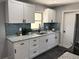 Well-lit kitchen boasts white cabinetry, sleek black hardware, and stylish backsplash at 1461 17Th St, Sarasota, FL 34234