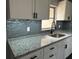 Kitchen featuring granite counters, modern faucet, white cabinets, and tile backsplash at 1461 17Th St, Sarasota, FL 34234