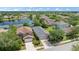 Aerial view of the home with a large lake in the back, green grass and mature trees at 15032 Skip Jack Loop, Lakewood Ranch, FL 34202