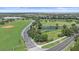 An aerial view shows a pond, a park, a road, and a sidewalk surrounded by green trees and grass at 15032 Skip Jack Loop, Lakewood Ranch, FL 34202