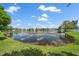 A view of the lake from the home's lush backyard, showcasing serene water views at 15032 Skip Jack Loop, Lakewood Ranch, FL 34202