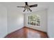 Bright bedroom with hardwood floors, ceiling fan, and large window with neighborhood views at 15032 Skip Jack Loop, Lakewood Ranch, FL 34202