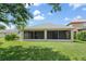 Rear exterior view of the home shows the screened lanai and well-maintained lawn at 15032 Skip Jack Loop, Lakewood Ranch, FL 34202