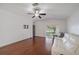 Cozy living room with hardwood floors, ceiling fan, and sliding glass doors to outdoor area at 15032 Skip Jack Loop, Lakewood Ranch, FL 34202