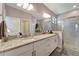Bathroom with double sink vanity, granite countertops, and glass-enclosed shower at 15719 Barefoot Beach Dr, Lakewood Ranch, FL 34211