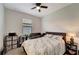 Cozy bedroom featuring a ceiling fan, neutral paint, window with blinds, and stylish furnishings at 15719 Barefoot Beach Dr, Lakewood Ranch, FL 34211