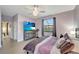 Bedroom with decorative ceiling fan, wood-look flooring, and dresser with television at 15719 Barefoot Beach Dr, Lakewood Ranch, FL 34211