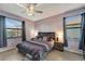 Bedroom with decorative ceiling fan, wood-look flooring, and views to screened lanai at 15719 Barefoot Beach Dr, Lakewood Ranch, FL 34211