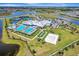 Aerial shot of community amenities including pool, clubhouse, beach volleyball, and tennis courts at 15719 Barefoot Beach Dr, Lakewood Ranch, FL 34211