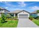 Charming single-story home with well-manicured landscaping and a gray two-car garage at 15719 Barefoot Beach Dr, Lakewood Ranch, FL 34211