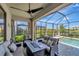 Outdoor patio featuring comfortable seating, a fire pit, and a screened-in pool area with a view of the water at 15719 Barefoot Beach Dr, Lakewood Ranch, FL 34211