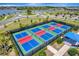 Aerial view of pickleball courts featuring a bright playing surface and shaded seating at 15719 Barefoot Beach Dr, Lakewood Ranch, FL 34211