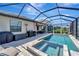 Screened-in pool and jacuzzi area featuring a bar, grill, and patio seating at 15719 Barefoot Beach Dr, Lakewood Ranch, FL 34211