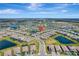 Expansive aerial view showcasing a well-planned community with numerous homes, serene lakes, and lush green spaces at 15719 Barefoot Beach Dr, Lakewood Ranch, FL 34211