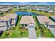 Aerial view of a neighborhood showcasing well-maintained lawns and landscaping with a central pond at 15719 Barefoot Beach Dr, Lakewood Ranch, FL 34211