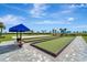 Outdoor bocce ball court with manicured green surfaces and a shaded seating area at 15719 Barefoot Beach Dr, Lakewood Ranch, FL 34211